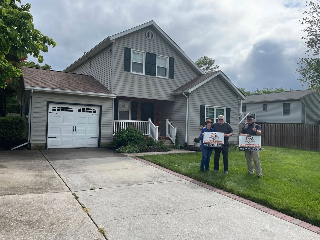 Homeowner celebrating a completed roof replacement by Sky Shield